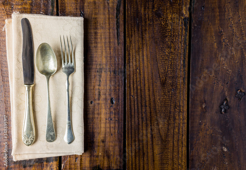 Cutlery set on a rustic wooden table. Fork, spoon and knife. Food concept. Copy Space