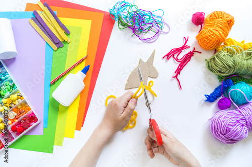 Unicorn cardboard and paper craft. Children's hands do.