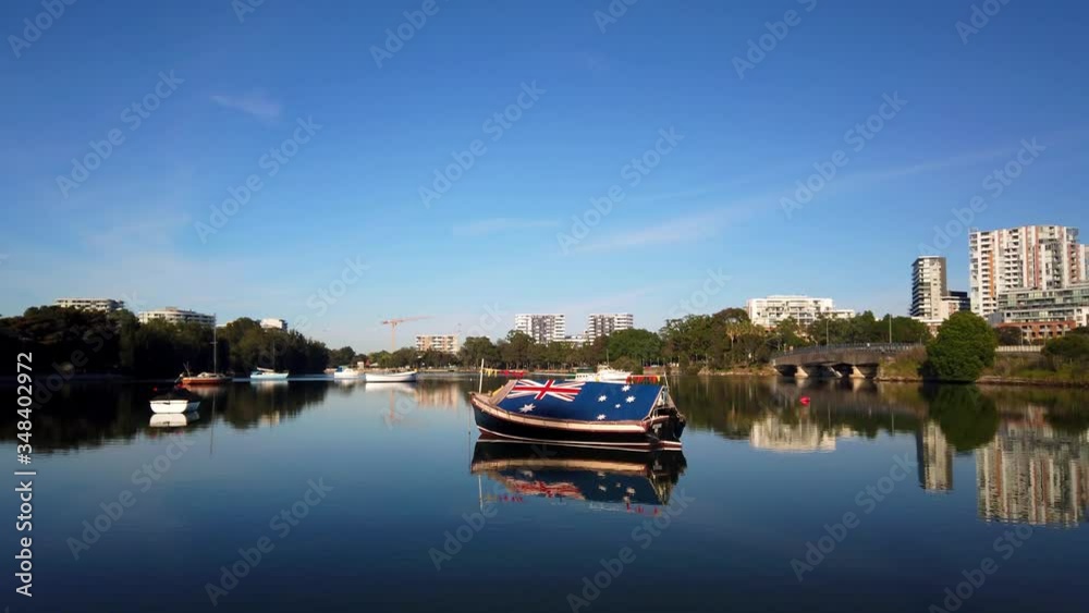 Small fishing boat with Australian Flag roof on a shallow river Small fishing boat with Australian Flag roof on a shallow river