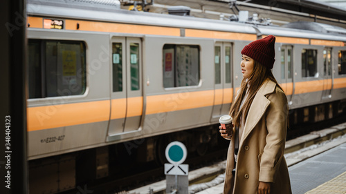 Young aisan woman waiting Train at platform in Japan, travel concept background.