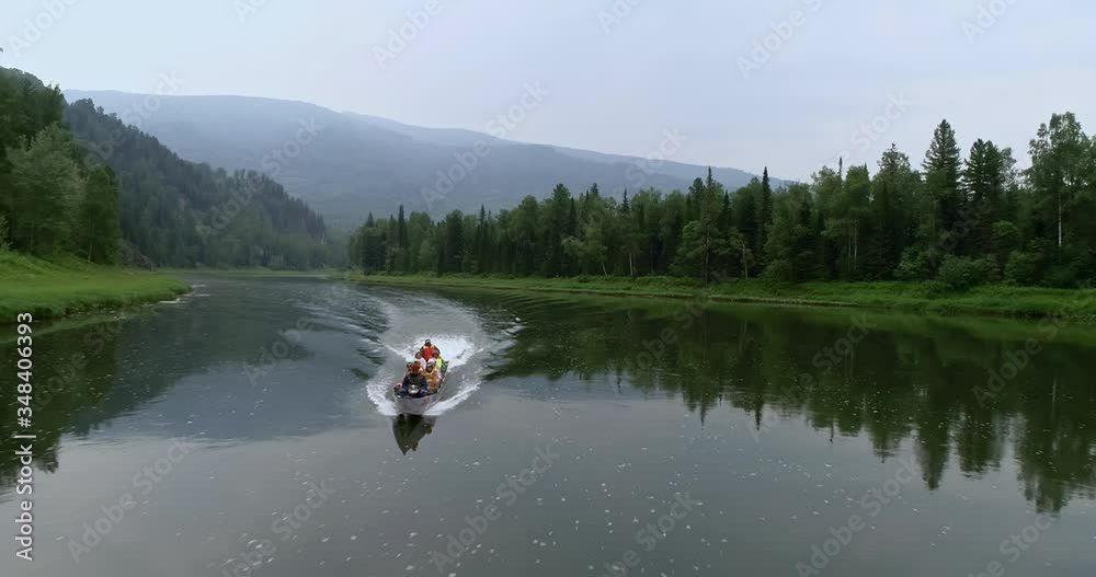 Boat in the river. Aerial view of the boat in the mountain. Summer. Day. People in the boat. a large canoe with a motor in the beautiful mountains. tourists in the wild Siberian taiga. 4k footage Boat in the river. Aerial view of the boat in the mountain. Summer. Day. People in the boat. a large canoe with a motor in the beautiful mountains. tourists in the wild Siberian taiga. 4k footage