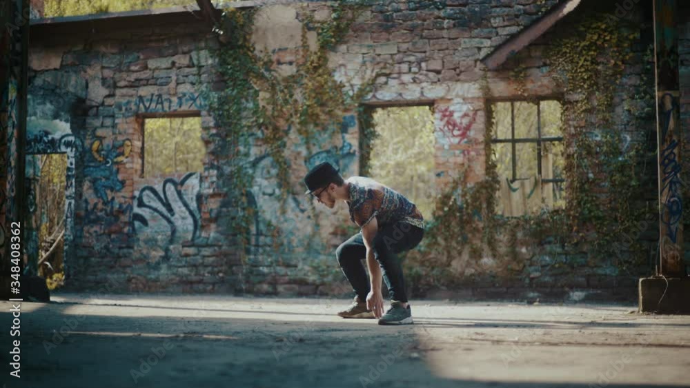Man dancing in abandoned building while wind blows dust away Man dancing in abandoned building while wind blows dust away