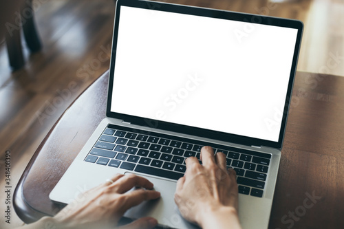 computer mockup image blank screen with white background for advertising,hand woman work using laptop contact business search information on desk at coffee shop.marketing and creative design