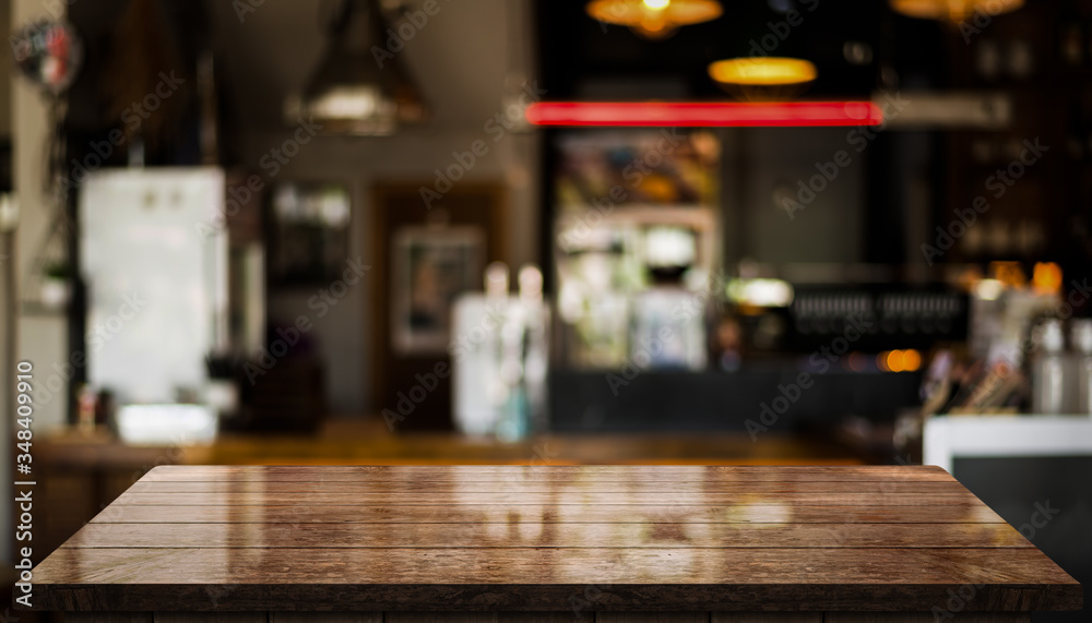 Empty old wood table top with bokeh coffee shop interior background.