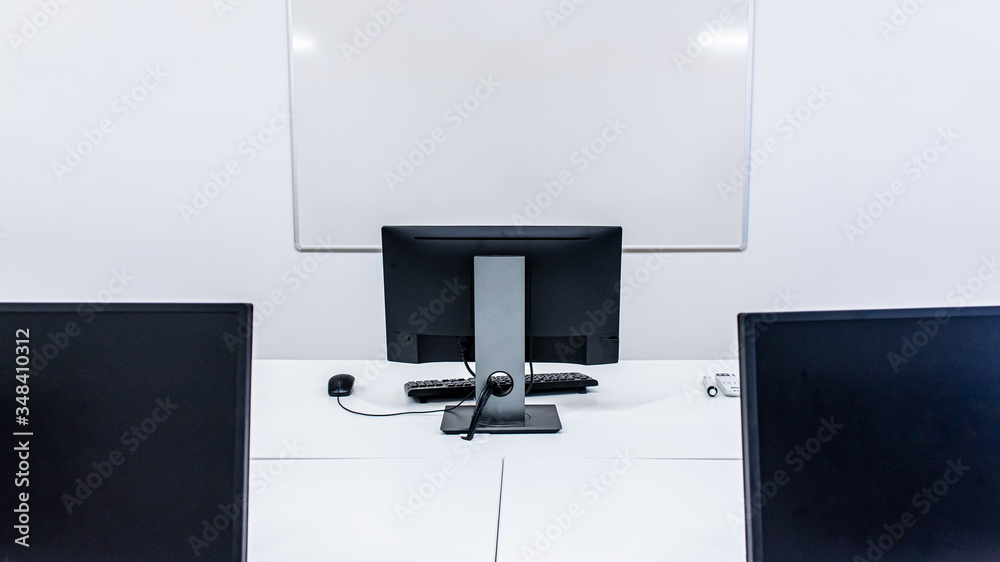 office room with computer tables with keyboard and mouse with a board and a projector