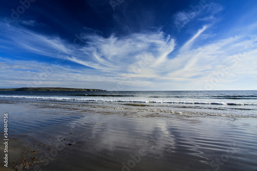 Wolkenwirbel spiegelt sich im flachen Wasser einer Bucht mit Sandstrand in Schottland © Richard
