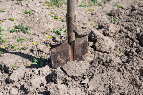 a shovel inserted into loose earth