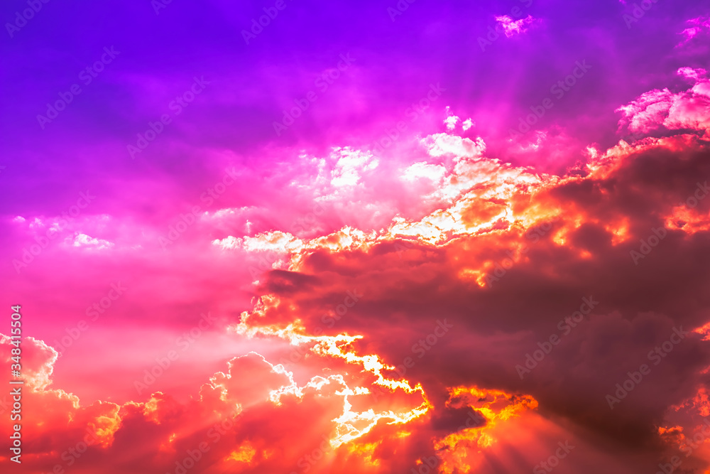 Bright Sun light behind red clouds in purple blue sky with pink and orange light Bright Sun light behind red clouds in purple blue sky with pink and orange light