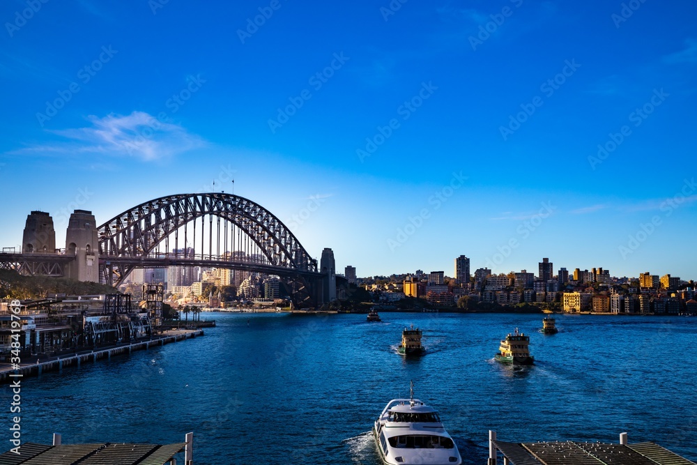 Sydney Harbour Australia on a sunny clear blue sky day with the turquoise colours of the bay and high rise offices of the City in the background