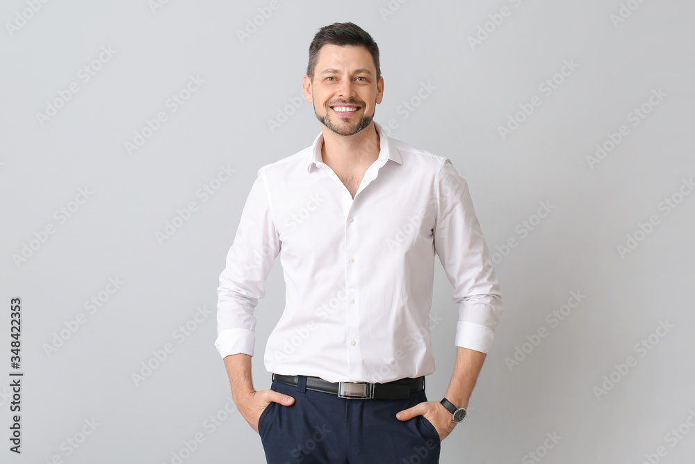 Fototapeta premium Portrait of handsome businessman on light background
