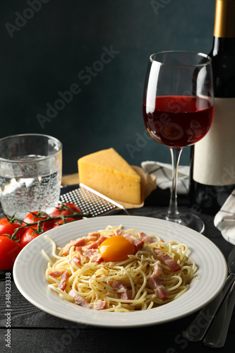 Composition with plate of tasty pasta and wine on wooden background