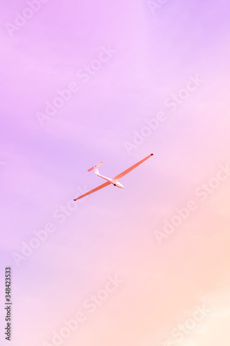 Small glider flying against the pink sky, concept of dream, happy future and positive outlook on life