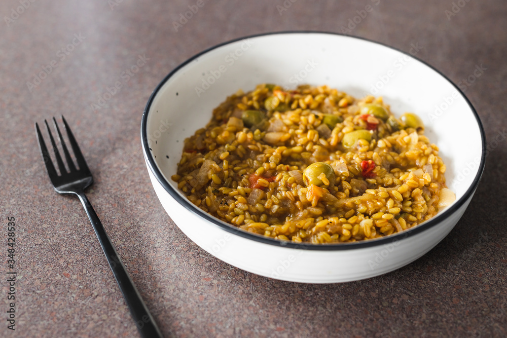 plant-based food, vegan farro with Mediterranean vegeteables and olives with Moroccan spices