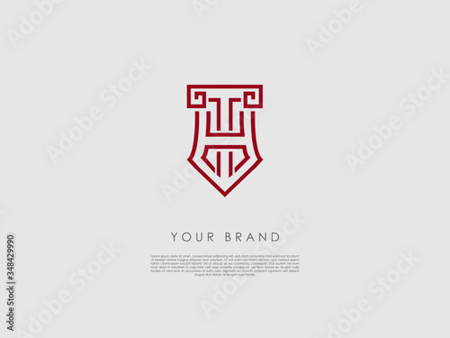 a red business logo that looks like a crest and has representations of an ancient column, tip of a pencil, letter h and t photo