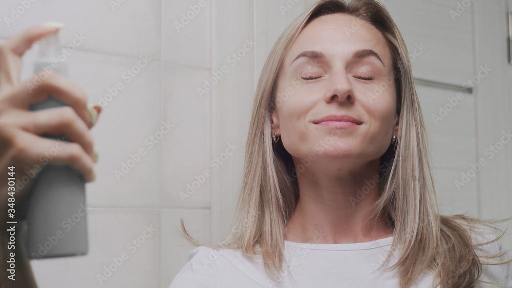 Close up Woman applying water spray for skin hydration Close up Woman applying water spray for skin hydration