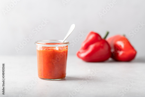 Balkan dish ajvar in a glass on a light background, minimalism style.