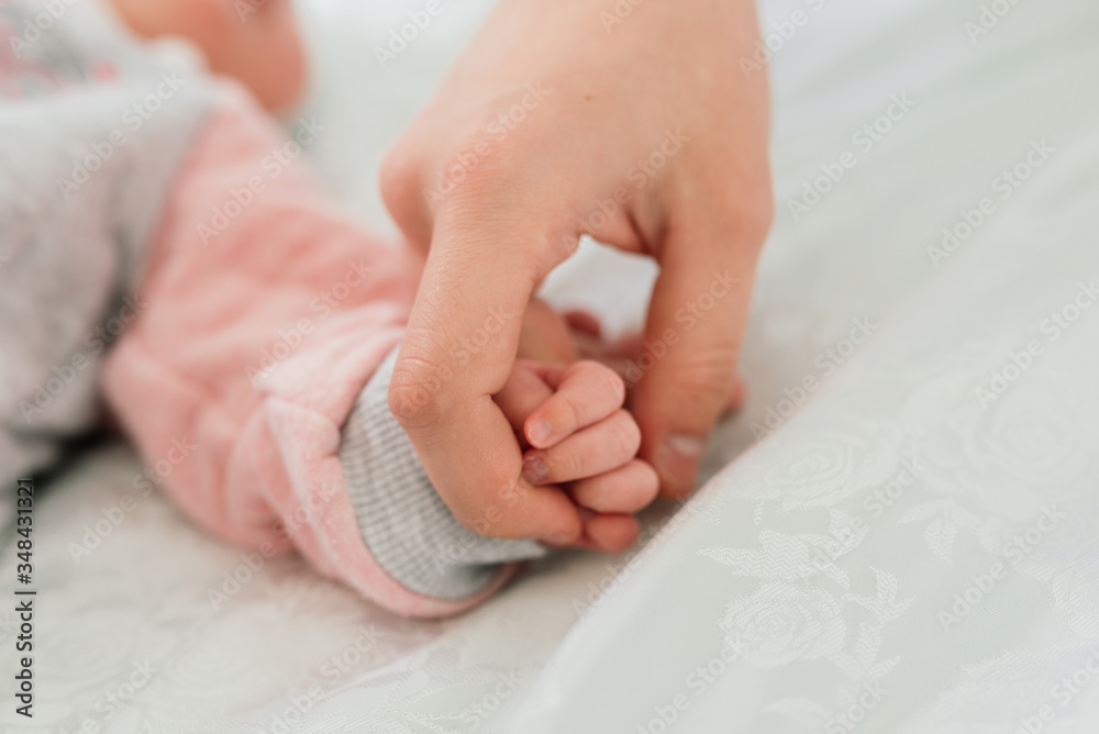 Family Baby Hands. Father and Mother Holding Newborn Kid. Child Hand Closeup into Parents Family Baby Hands. Father and Mother Holding Newborn Kid. Child Hand Closeup into Parents