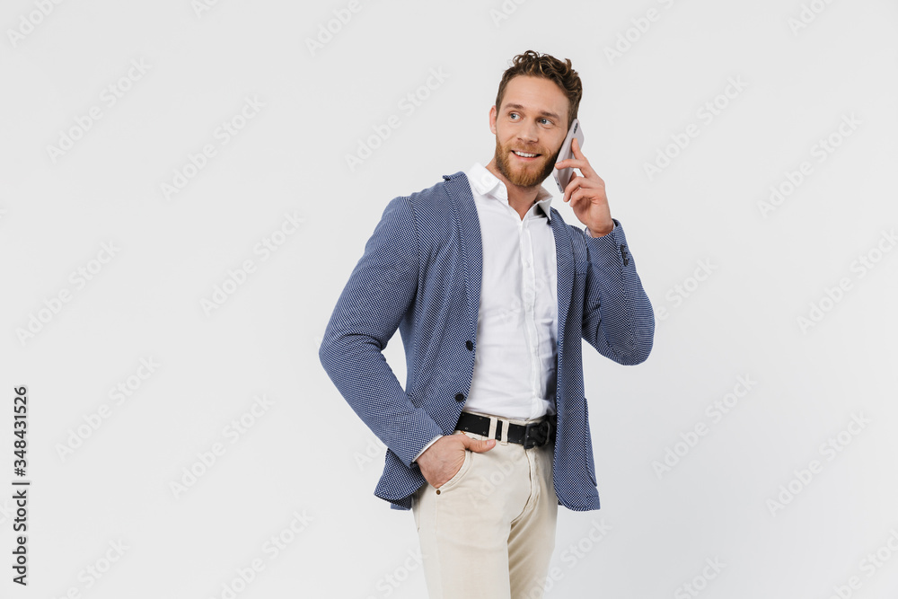 Image of pleased handsome man smiling and talking on smartphone Image of pleased handsome man smiling and talking on smartphone