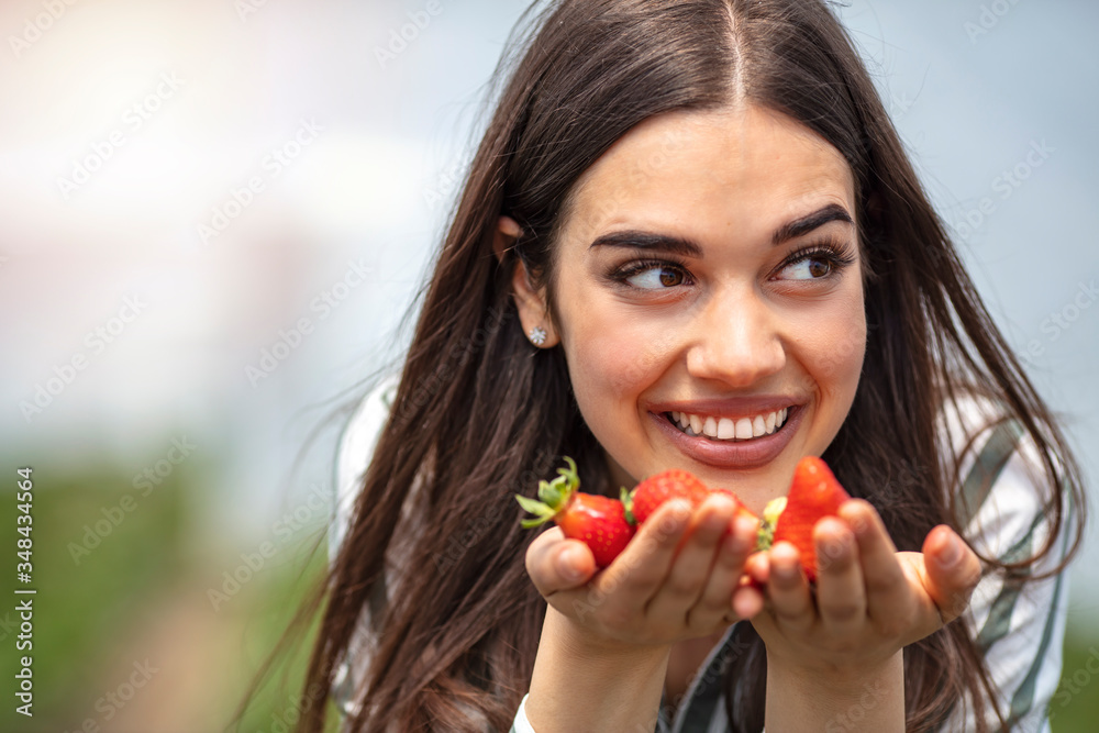 Young Latin woman tasting delicious strawberries. Close-up. Happy young woman eating strawberry. Healthy happy smiling woman eating strawberry. Pretty brunette eating strawberries Young Latin woman tasting delicious strawberries. Close-up. Happy young woman eating strawberry. Healthy happy smiling woman eating strawberry. Pretty brunette eating strawberries