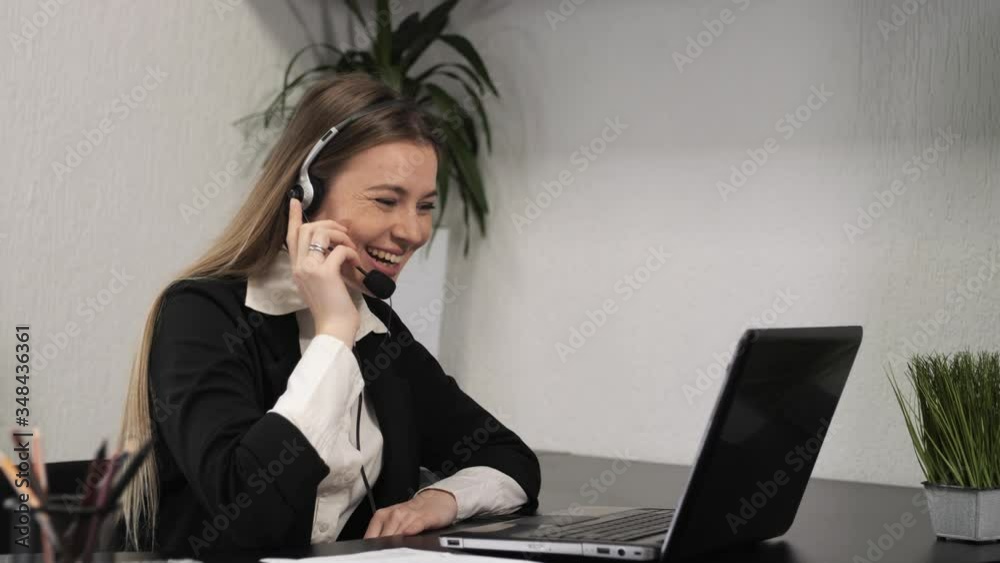 Attractive customer support agent or call center with headset works on desktop computer while supporting the customer on phone call. Operator service business representative concept.Slow motion Attractive customer support agent or call center with headset works on desktop computer while supporting the customer on phone call. Operator service business representative concept.Slow motion