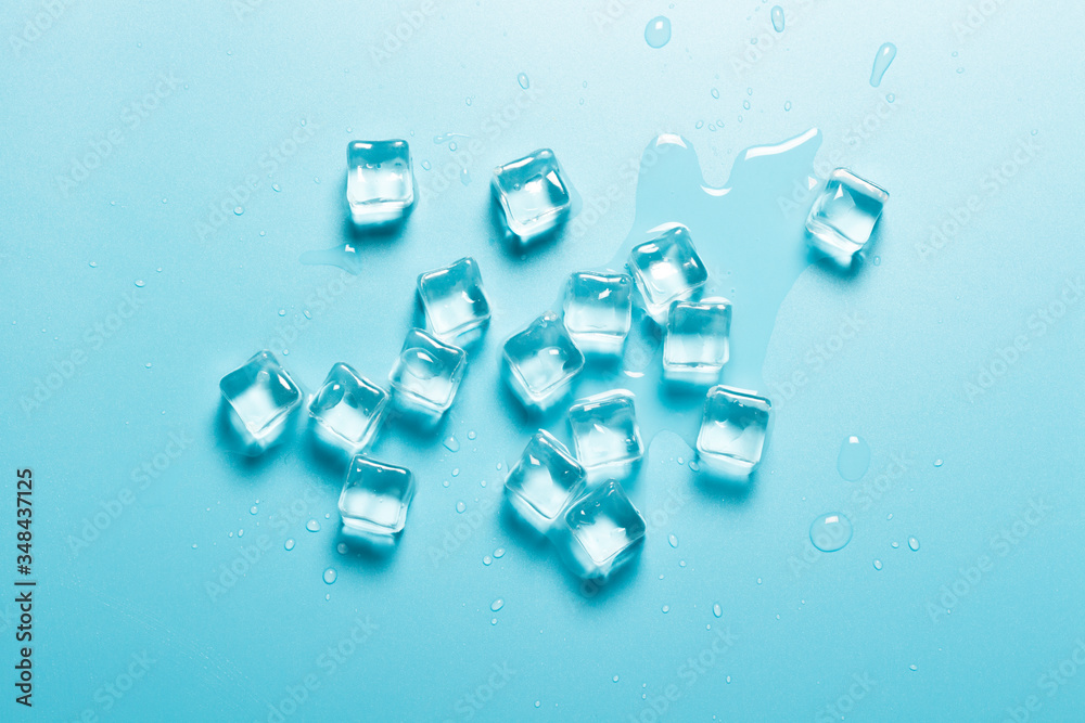 Ice cubes with water on a blue background. Ice concept for drinks. Banner. Flat lay, top view Ice cubes with water on a blue background. Ice concept for drinks. Banner. Flat lay, top view