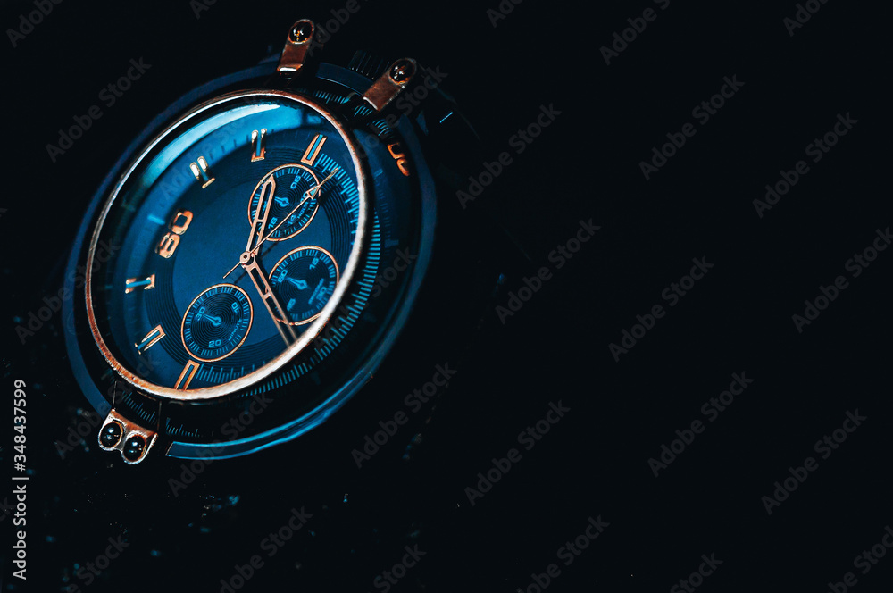 Metallic gold Phantom Blue men's watch on a black background. 