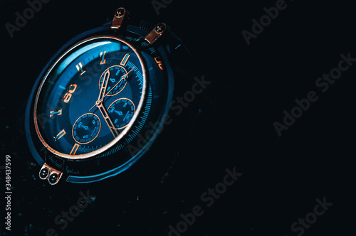 Metallic gold Phantom Blue men's watch on a black background. 