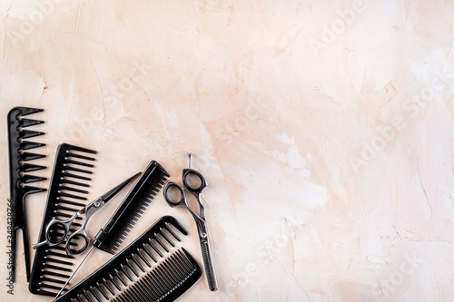 Combs, hairbrush, scissors on beige background top view copy space