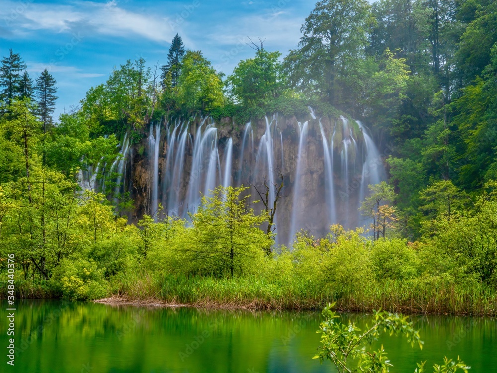 Long exposure of a beautiful set of waterfalls set in the vibrant green forest of Plitvice Lakes National Park, Croatia.