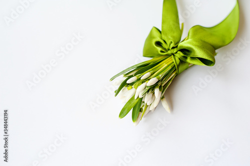 spring white flowers tied up in satin ribbon on white background. A place to insert text against a white background. Selective focus.