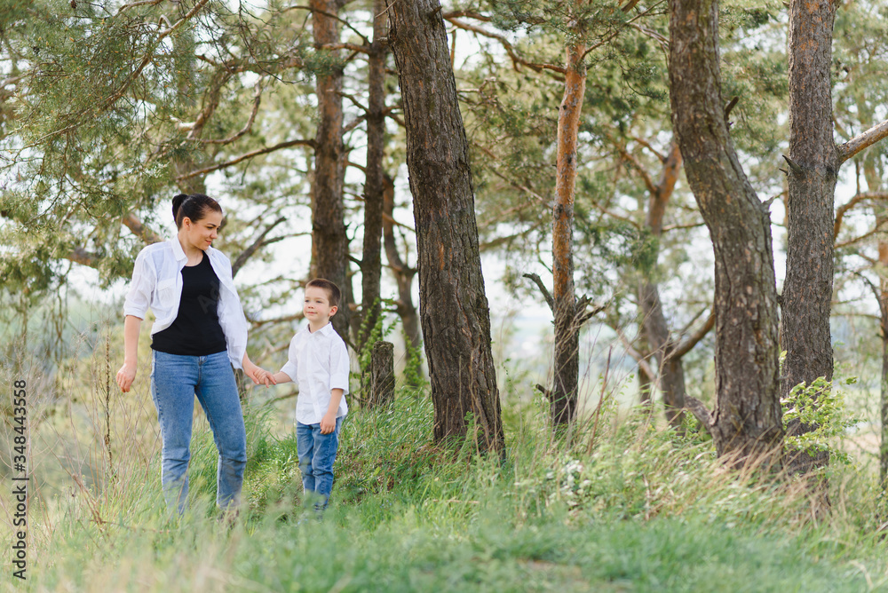Fototapeta premium Happy family! Mother with son child playing having fun together on the grass in sunny summer day, life moment