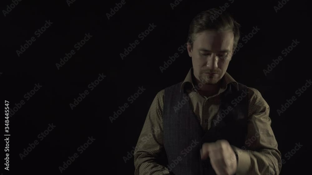 A man in a suit on a black background puts on a gas mask and crosses his arms over his chest A man in a suit on a black background puts on a gas mask and crosses his arms over his chest