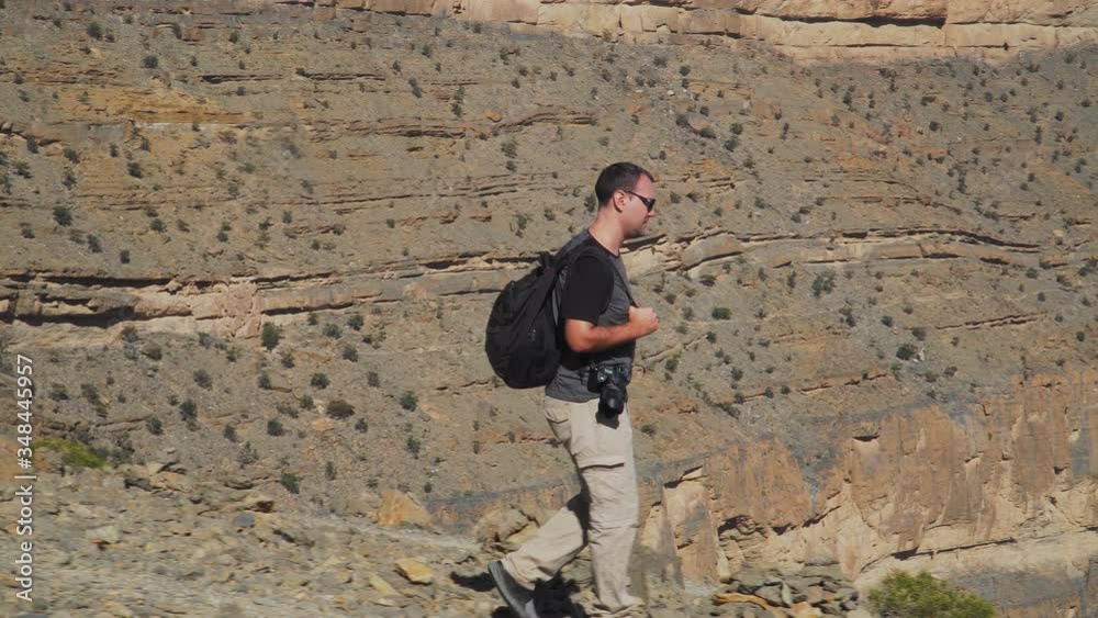 Young Foreign Male Tourist Hiking along Balcony Walk Trail at Wadi Ghul aka Grand Canyon of Oman in Jebel Shams Mountains. Man in Active Solo Travel in Middle East Countries