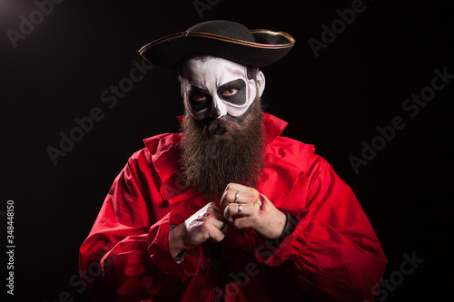 Bearded man disguised as a dangerous pirate over black background.