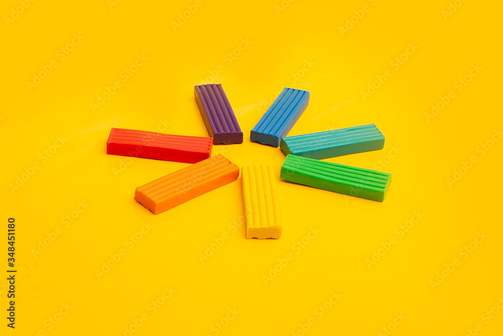 plasticine of rainbow colors is laid out on a yellow background in the form of the sun plasticine of rainbow colors is laid out on a yellow background in the form of the sun