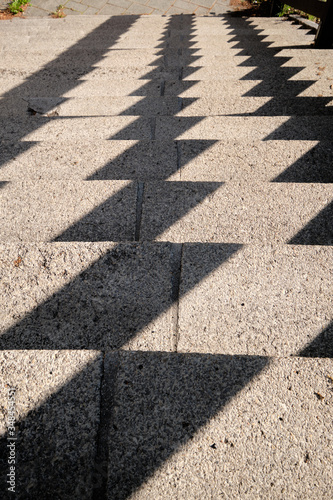 Abstract background shot with a pattern created by harsh shadows on a concrete staircase in the city. Seen in Germany in May.