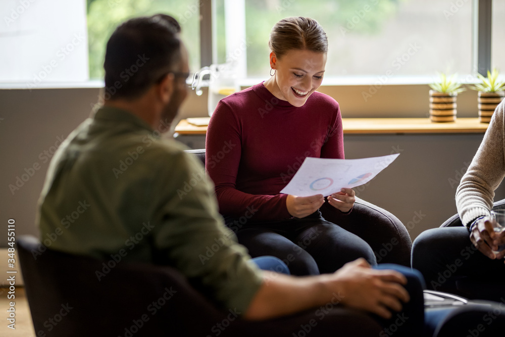 Smiling businesswoman going over some charts during an office me Smiling businesswoman going over some charts during an office me