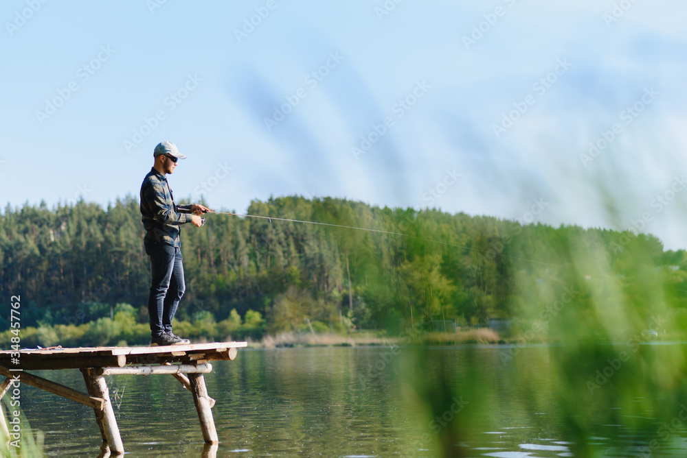 A man catches a fish on a spinning fishing in the summer