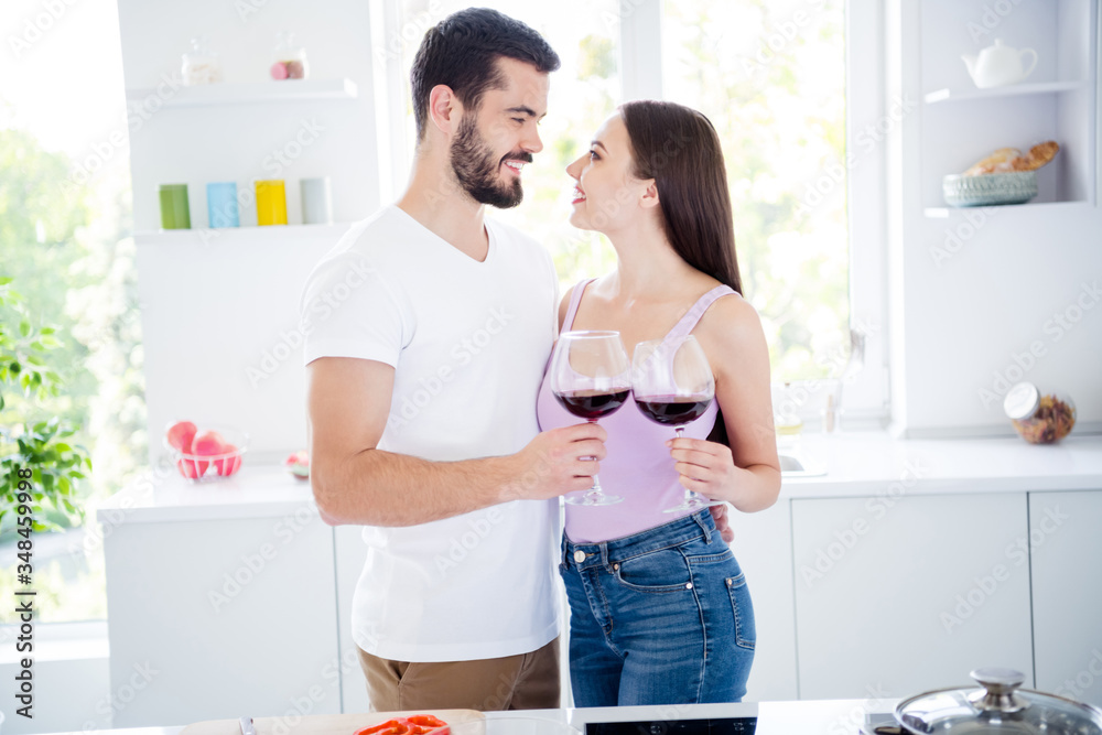 Profile side photo of two people married bonding spouses have passionate date evening dinner meal hold wine glass cheers toast clink woman man hug embrace tender in house kitchen indoors Profile side photo of two people married bonding spouses have passionate date evening dinner meal hold wine glass cheers toast clink woman man hug embrace tender in house kitchen indoors