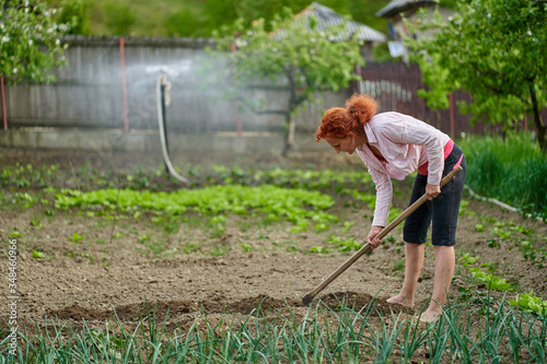 Woman hoeing in her garden
