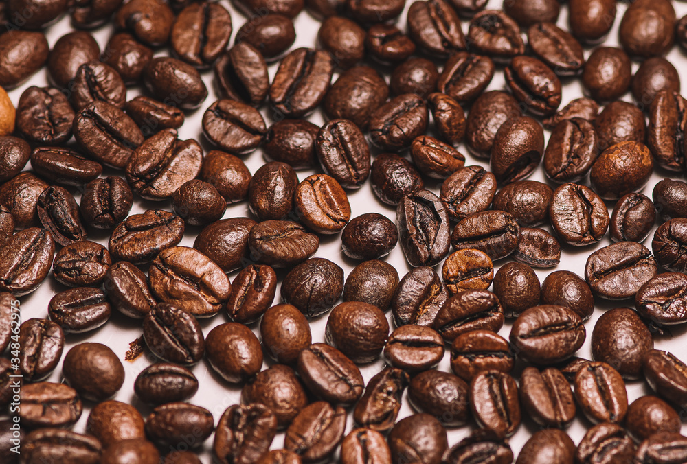 Fototapeta premium Roasted coffee beans scattered in close-up photo