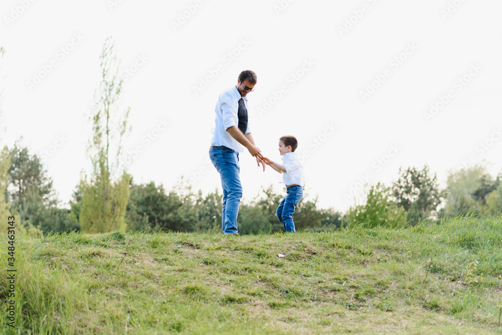 father and son have fun together in nature. Father and son playing. People having fun outdoors. Concept of friendly family.