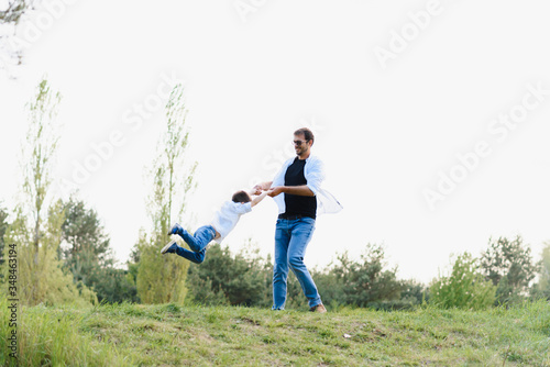 father and son have fun together in nature. Father and son playing. People having fun outdoors. Concept of friendly family.