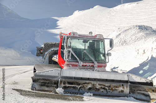 Ratrack machine at the High alpine Road in Austria in Spring Alpine mountains with snow. 