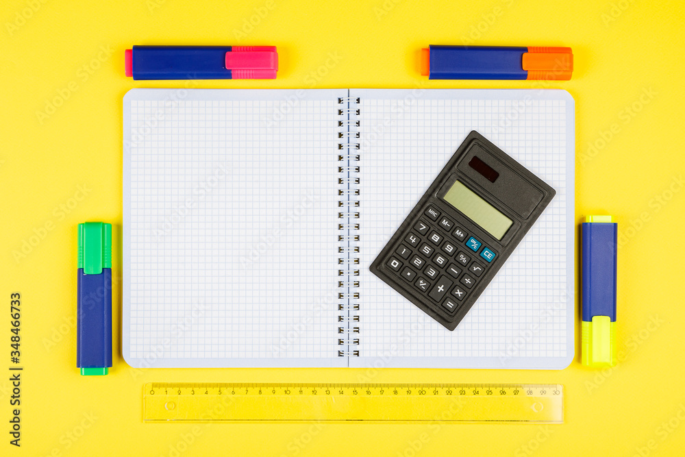 Back to school. School supplies on yellow background. Calculator, scissors, pen, notebook isolated on yellow. Back to school. School supplies on yellow background. Calculator, scissors, pen, notebook isolated on yellow.