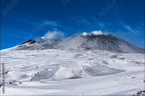 Snowy volcano with smoke in sicily