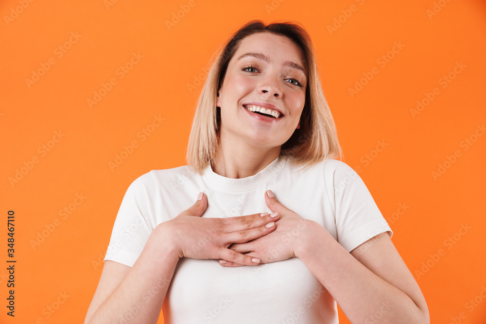 Image of joyful pretty woman smiling and holding her hands on chest Image of joyful pretty woman smiling and holding her hands on chest