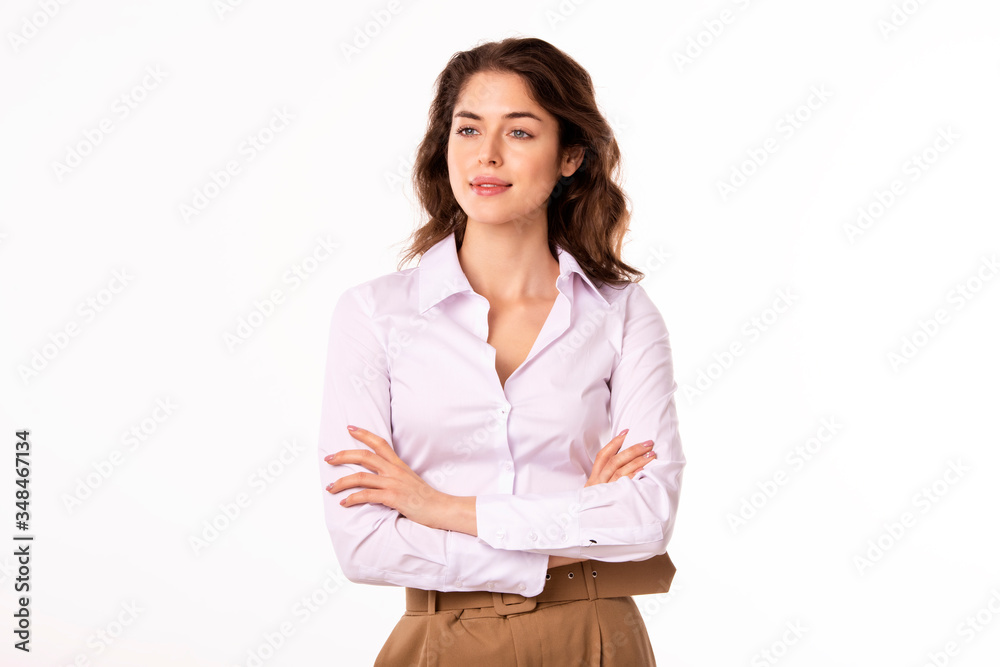Attractive woman standing with arms crossed and smiling while standing at isolated white background Attractive woman standing with arms crossed and smiling while standing at isolated white background