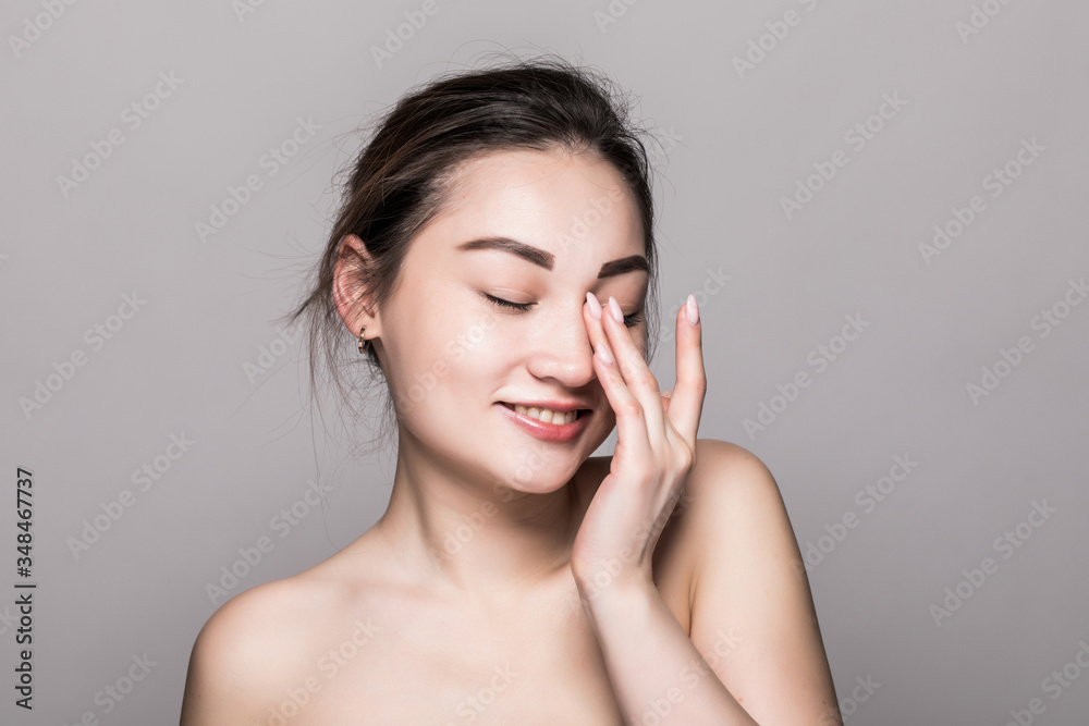 Young attractive asian woman skin care on gray background