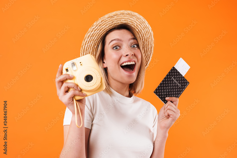 Image of smiling woman holding passport with tickets and camera Image of smiling woman holding passport with tickets and camera